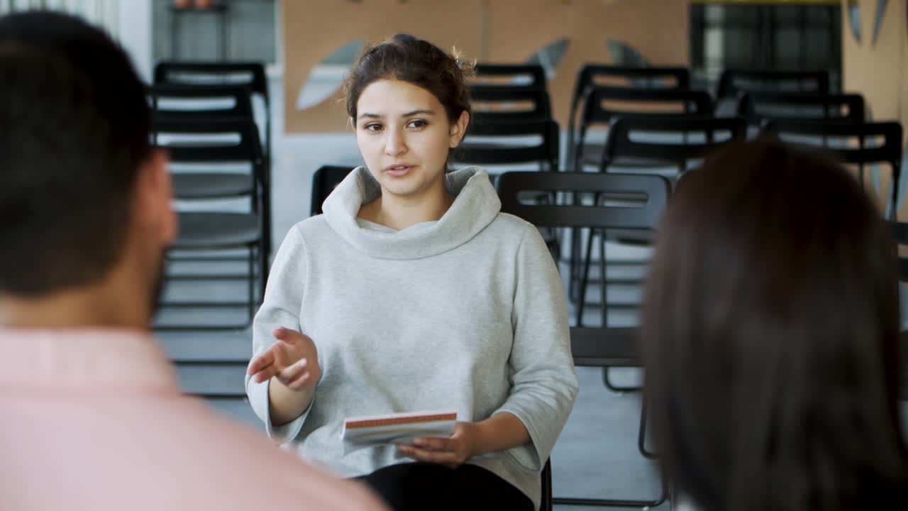 un joven psicólogo enfocado hablando con los trabajadores.