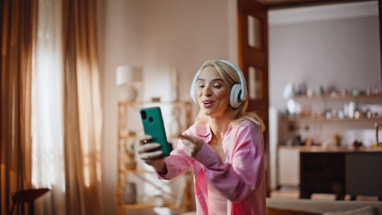 Singing woman taking selfie moving body in living room closeup. Girl dancing