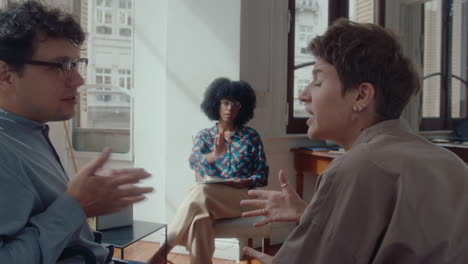 couple quarrelling and therapist calming them down on consultation