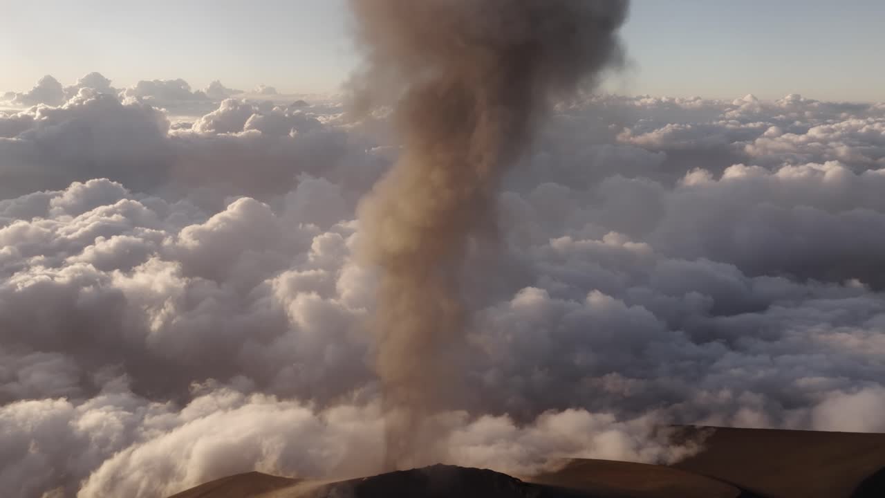 Vista aerea del Volcán de Fuego che mostra una forte attività eruttiva con fumo scuro che si alza dalla caldera.