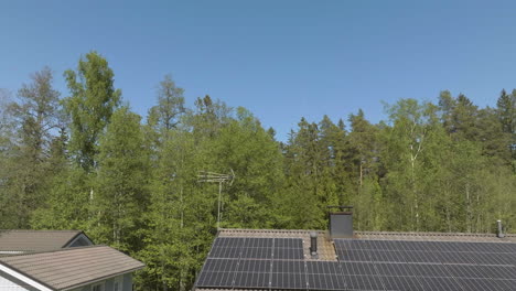 Aerial tilt shot of clear sky and solar panels on a house roof, sunny, summer day