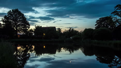 Wolken-Fließen-über-Der-Silhouette-Der-Holzhütte,-Während-Der-Mond-Aufgeht