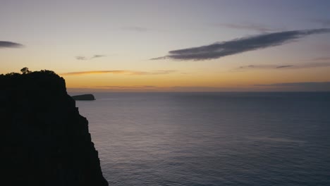 colorful sunrise behind sea cliffs over the ocean