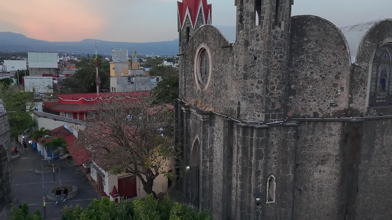 Crane down tilt up drone shot of Calvary's Church during the day in Cuernavaca, Morelos, Mexico