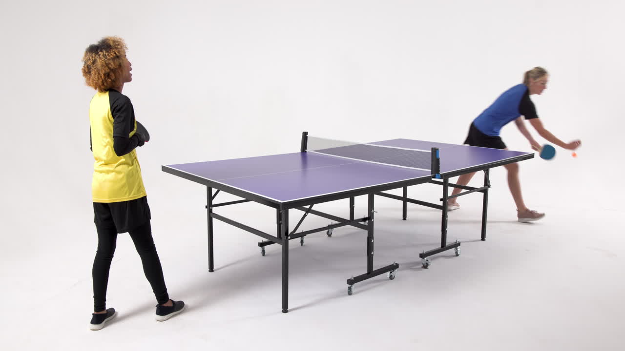 Multiracial female table tennis players, serving and passing the ball on white background