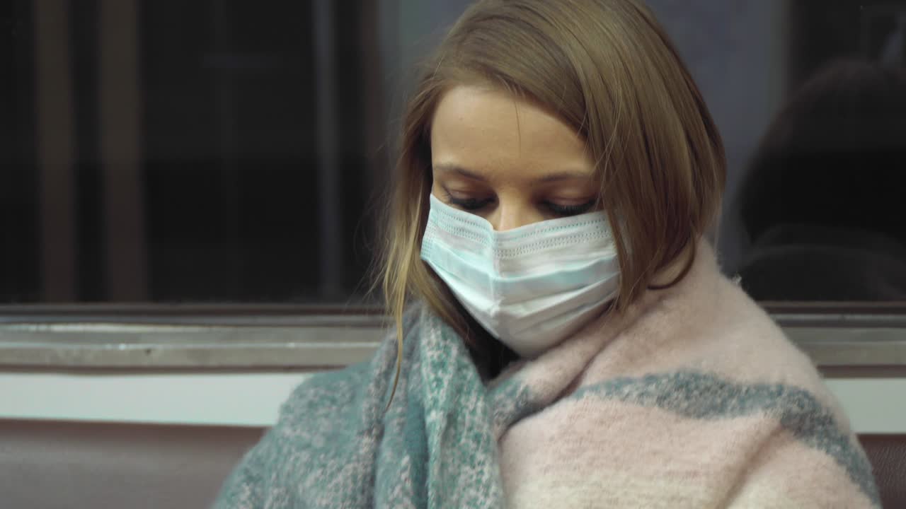 niña con una máscara médica de pie en un vagón del metro