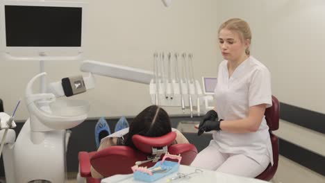 a dental assistant is demonstrating various tools and effective care techniques in a professional clinical setting.