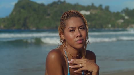 auf einem hellen tag am strand von las cuevas, trinidad in der karibik, entspannt sich ein junges mädchen mit lockigem haar in einem bikini am meer