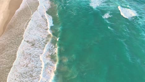 aerial view of ocean waves hitting the shore