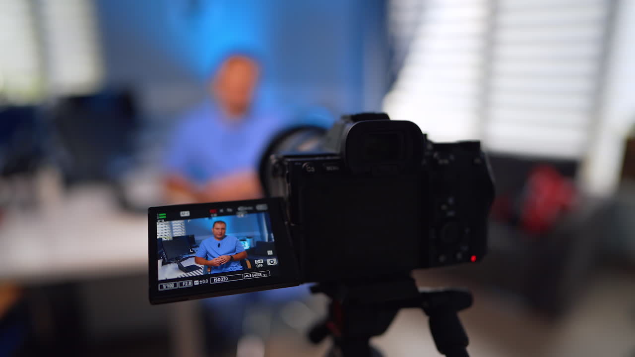 Male medic in blue uniform on the display of modern camera. Close up. Medical vlogging concept. Selective focus