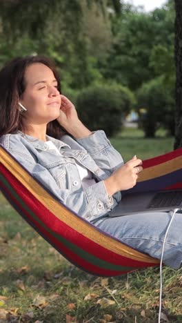 woman relaxing in a hammock with laptop