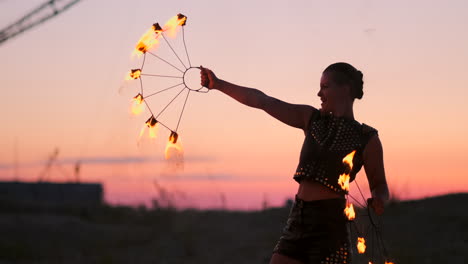 Fire-dancers-against-sunset.-A-young-woman-poses-with-her-fire-hoop-against-the-sunset-during-her-dance-performance