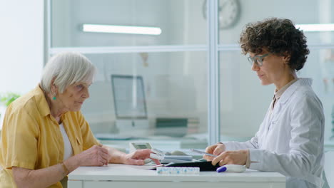 doctor giving pulse oximetry test to elderly woman