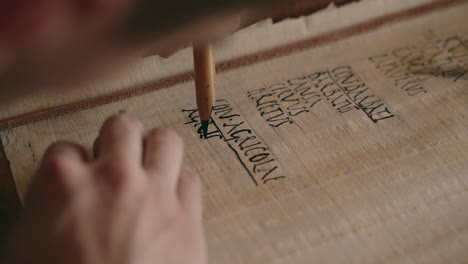 Person writing on papyrus scroll