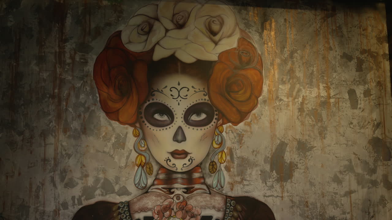 vista cercana de la colorida pintura de katrina adorna la pared, mostrando detalles intrincados y tonos vibrantes, rindiendo homenaje a la cultura mexicana y la celebración del día de los muertos
