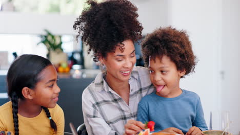 mother feeding children strawberry for breakfast