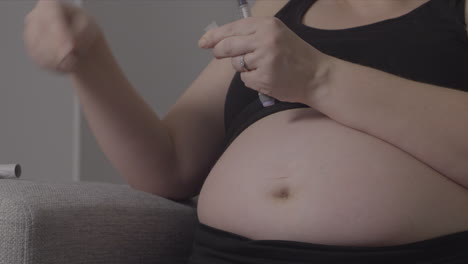 close up of pregnant diabetic woman preparing insulin syringe for injection