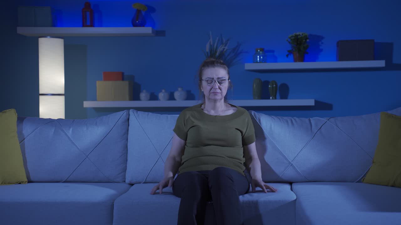 la mujer que presiona las almohadas en su cabeza con miedo.