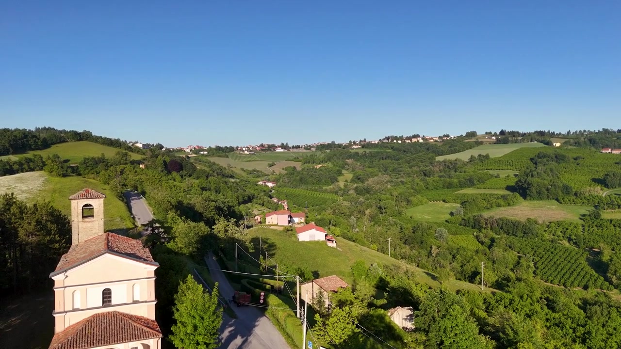 Des images de drone révèlent une église historique dominant des collines vallonnées et des vignobles luxuriants dans le Piémont.