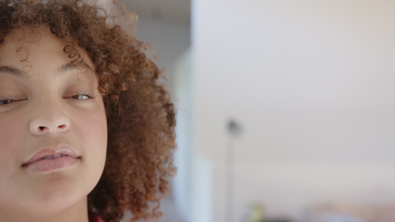 Close-up of woman with curly hair looking away, focusing on fitness goals, copy space