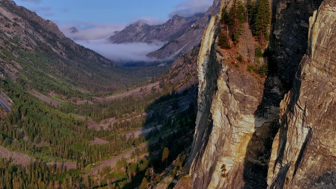 Borda dramática de penhasco de granito acima da floresta de Blodgett Canyon na Cordilheira Bitterroot, Montana