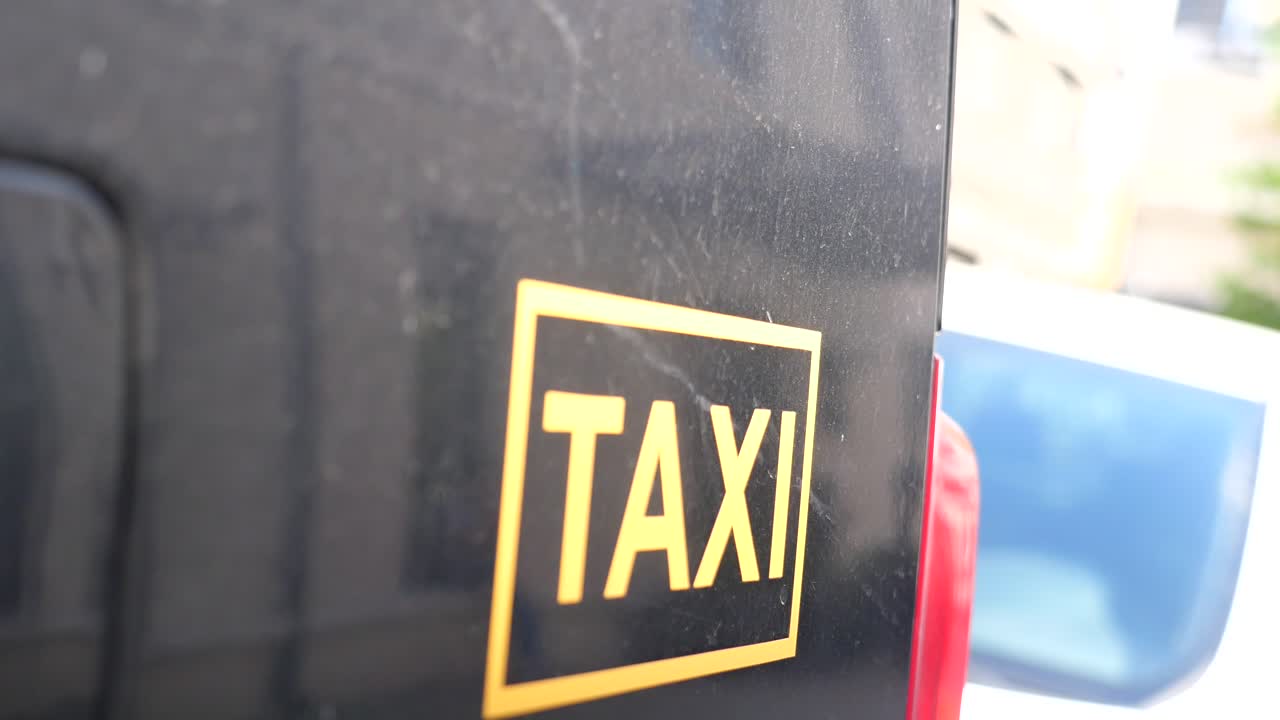 Taxiskilt på et sort køretøj