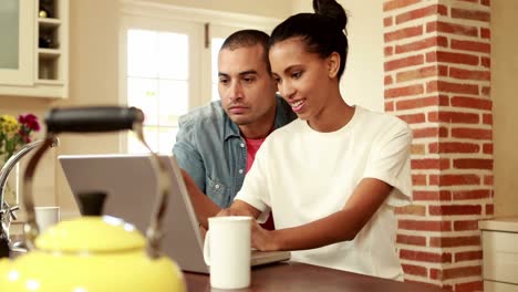 pareja feliz usando una computadora portátil