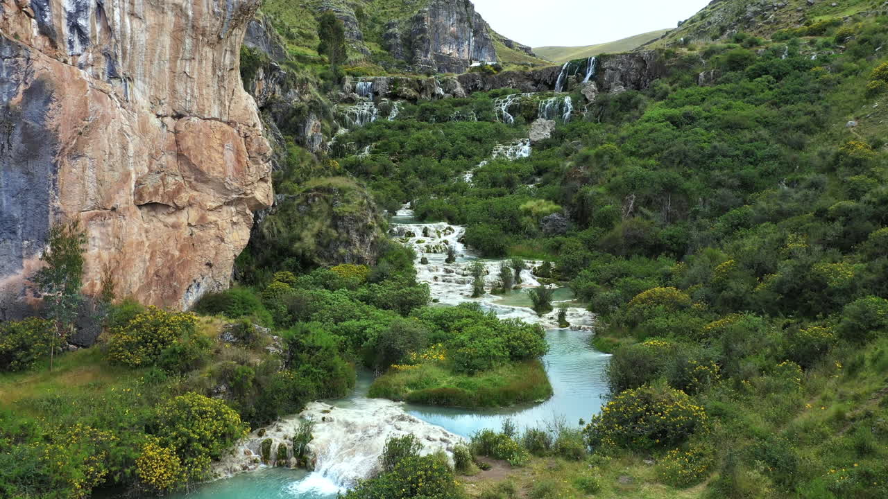 페루의 아야쿠초 (ayacucho) 에 있는 밀푸 (millpu) 라고 불리는 푸르키즈색 물이 있는 호수의 흐름을 밖으로 움직이는 드론으로 찍은 아름다운 사진입니다.