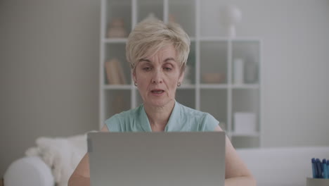 woman is working remotely from home during pandemic of covid-19 talking with colleagues or clients by laptop