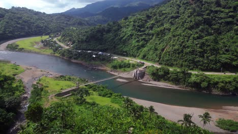 Empuje-De-Drones-Sobre-Un-Puente-Colgante-Que-Cruza-Un-Río-Ancho-En-El-Sudeste-Asiático