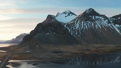 Captured-by-a-4K-drone,-aerial-cinematic-shots-showcase-the-breathtaking-vista-of-the-towering-Kirkjufell-mountain-peak