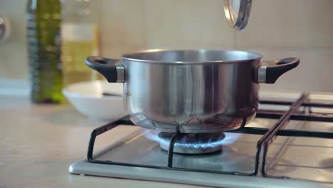 hand taking off lid from pan, dripping condensation