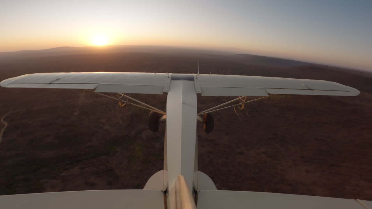 Aereo leggero sopra colline in silhouette all'alba in Kenya