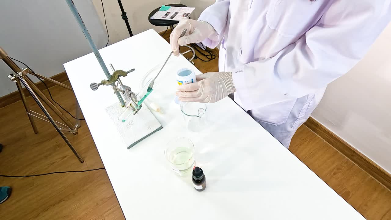 Scientist conducts chemical reaction between copper carbonate and sulfuric acid in a laboratory setting with precise measurements