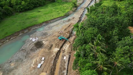 aerial orbit of excavator operating at river construction site in tropical island of virac, catanduanes.