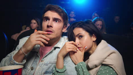 young couple feeling scare in movie theater