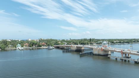 drone hyperlapse of drawbridge over intercoastal waterway in lantana florida showing fast moving boats on the water and fast moving cars on the bridge