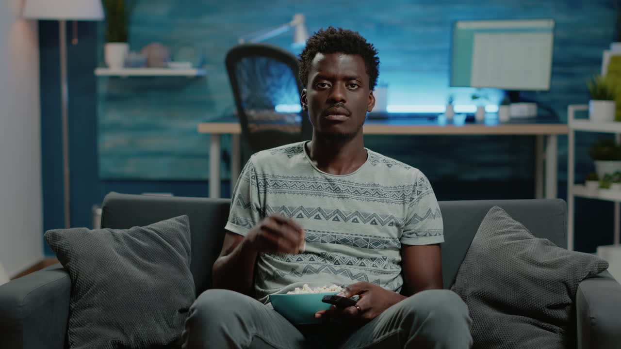 POV of adult switching channels with TV remote control