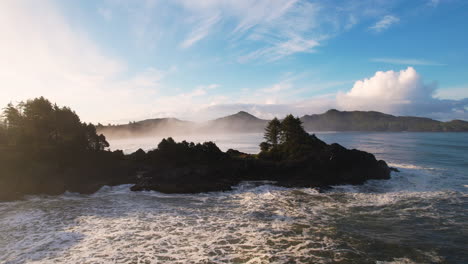 misty pacific ocean and pettinger point on a sunny morning in tofino, bc, canada