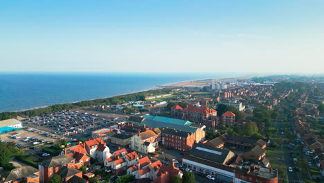 aerial video of skegness, lincolnshire, reveals its picturesque coastline, lively tourist scene, and famous pier on a summer evening