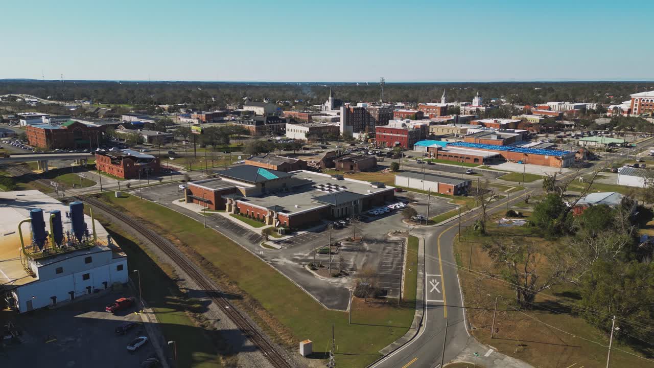 A Small Town Features a Mix of Industrial, Commercial, and Residential Buildings, With a Railway Line Running Through the Foregroun - Aerial Drone Shot