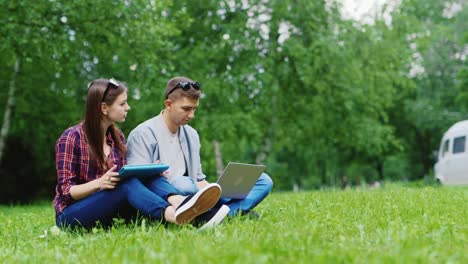 college students studying together in nature enjoy your tablet and laptop hd video