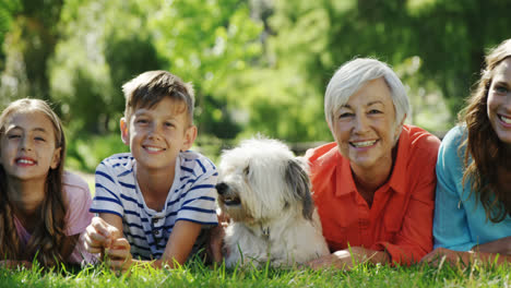 familia de varias generaciones relajándose con su perro en el parque