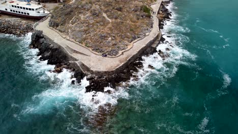 large waves splashing at the rocks in agios nikolaos in greece