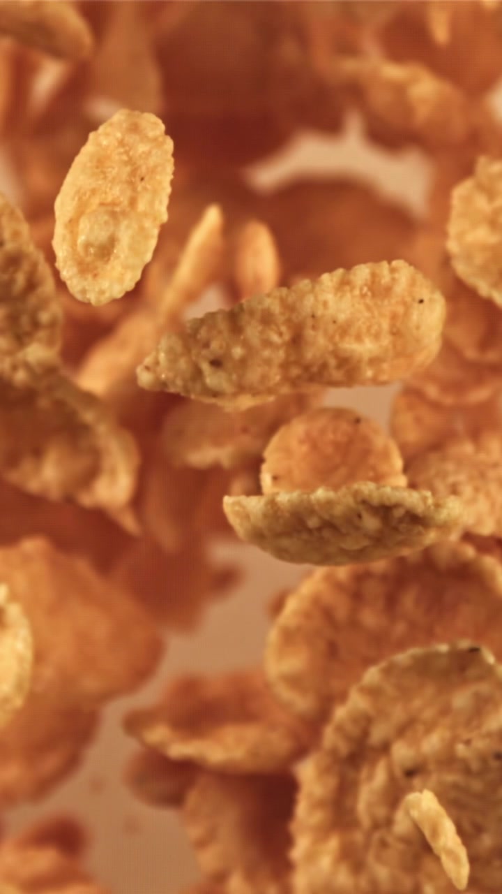 Flocos de cereal dourados caindo em câmera lenta