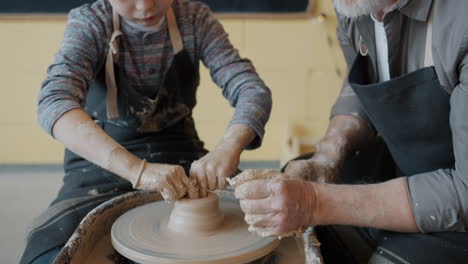 grandfather teaching grandson pottery