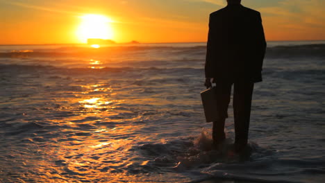 man in suit walking to the sea