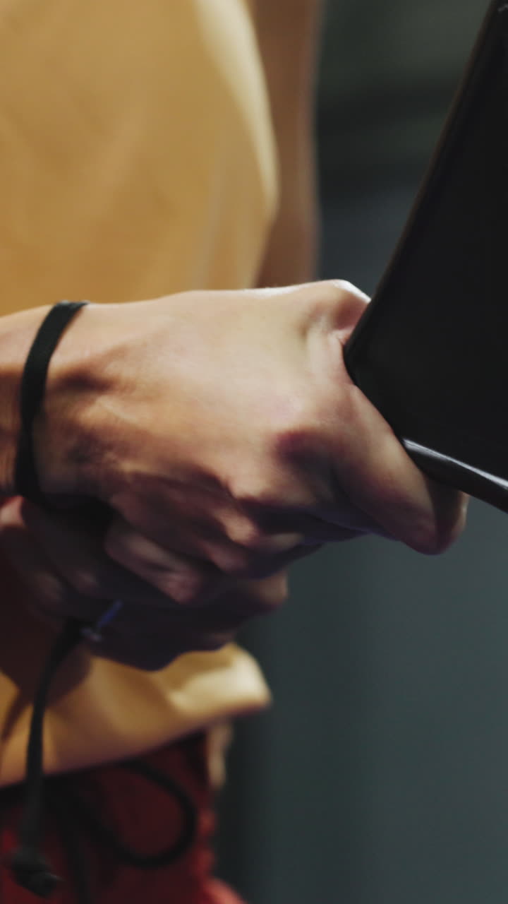Close-up of Hands Holding a Device and Adjusting a Wrist Strap