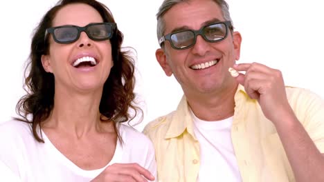 Happy-young-couple-wearing-3d-glasses-eating-popcorn