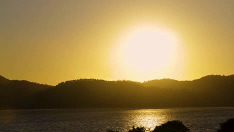 Time-lapse-of-sun-setting-behind-silhouetted-ridge